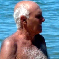 Bill Rogers Elderly balding man with white hair, standing shirtless in a body of blue water